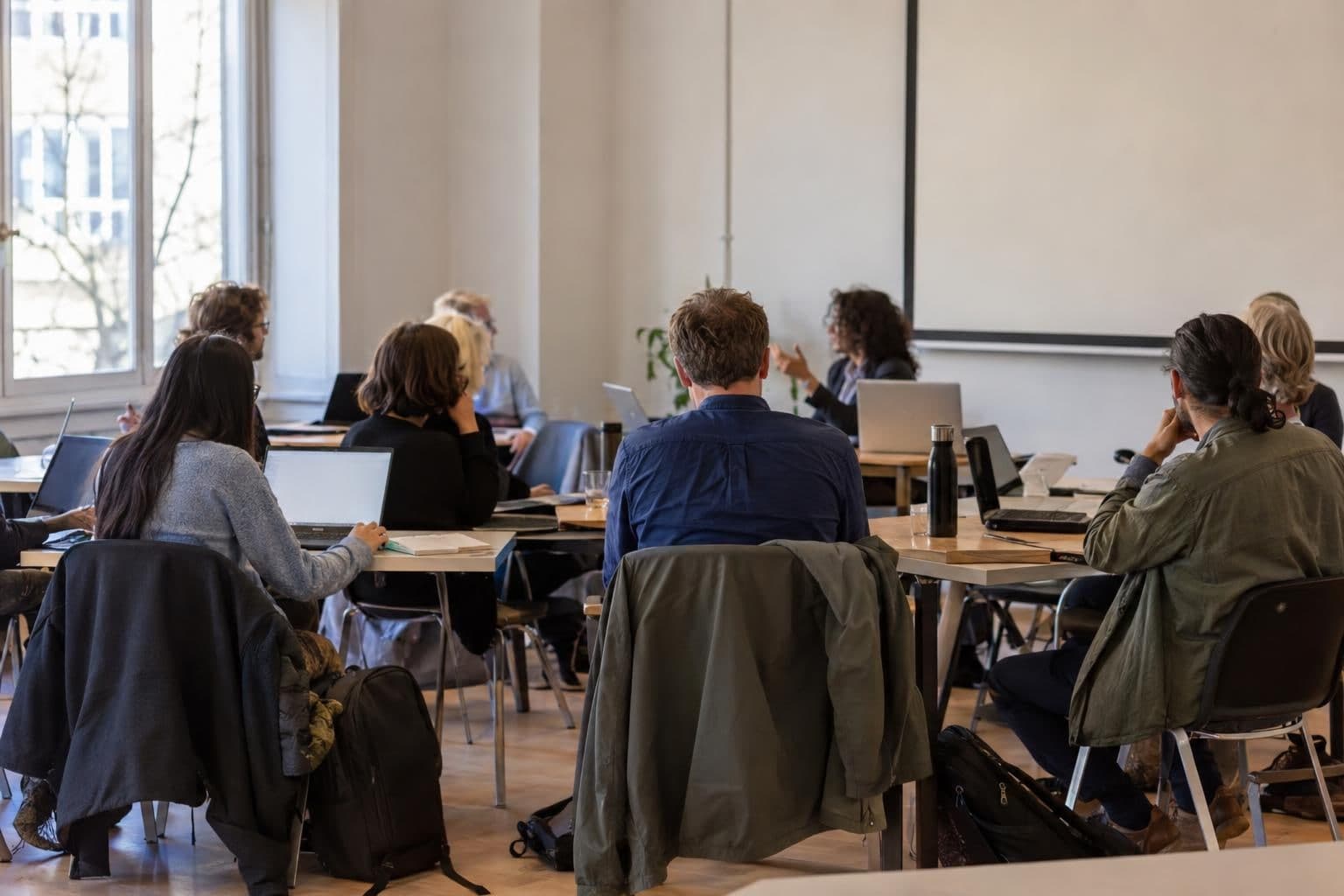 Researchers meet around laptops to discuss scientific software and research validation.