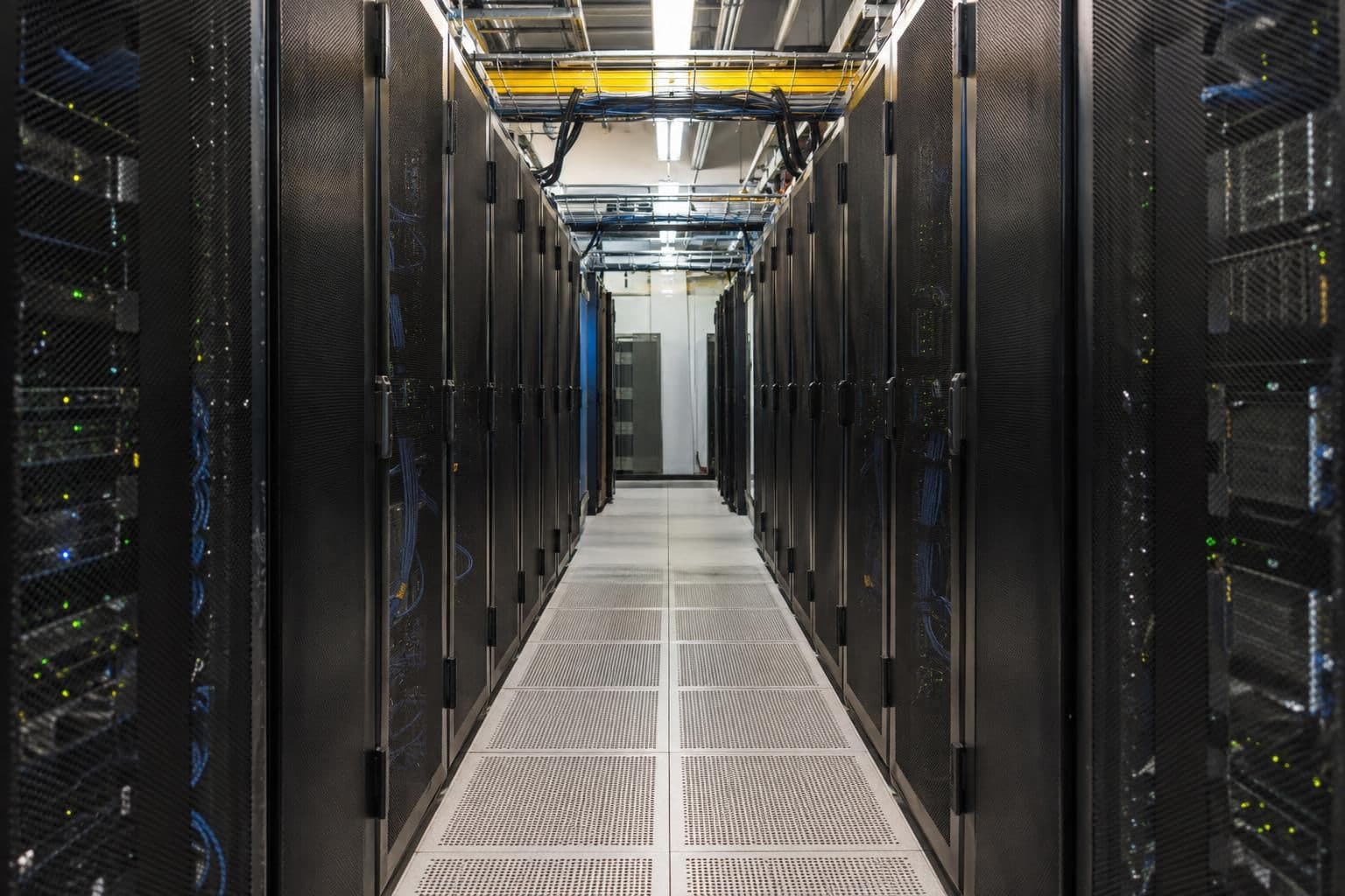 Rows of unmarked server racks in a quiet data-centre aisle.