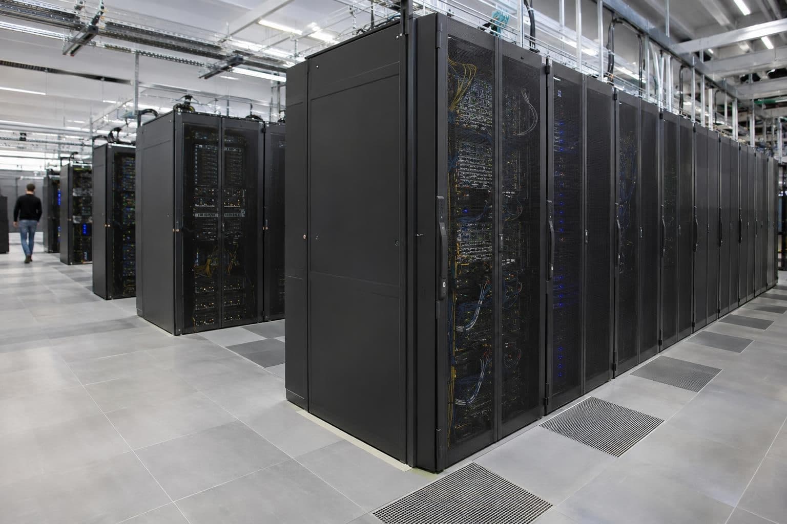 Installed supercomputer cabinets in an unbranded research computing facility.