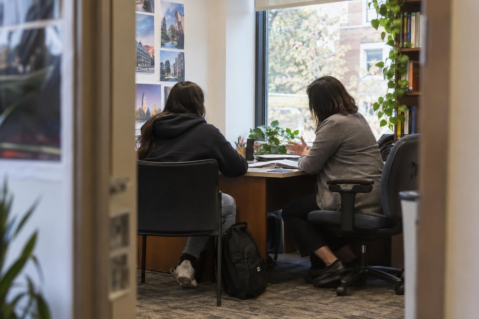 A high-school student discusses college application planning with an adviser.