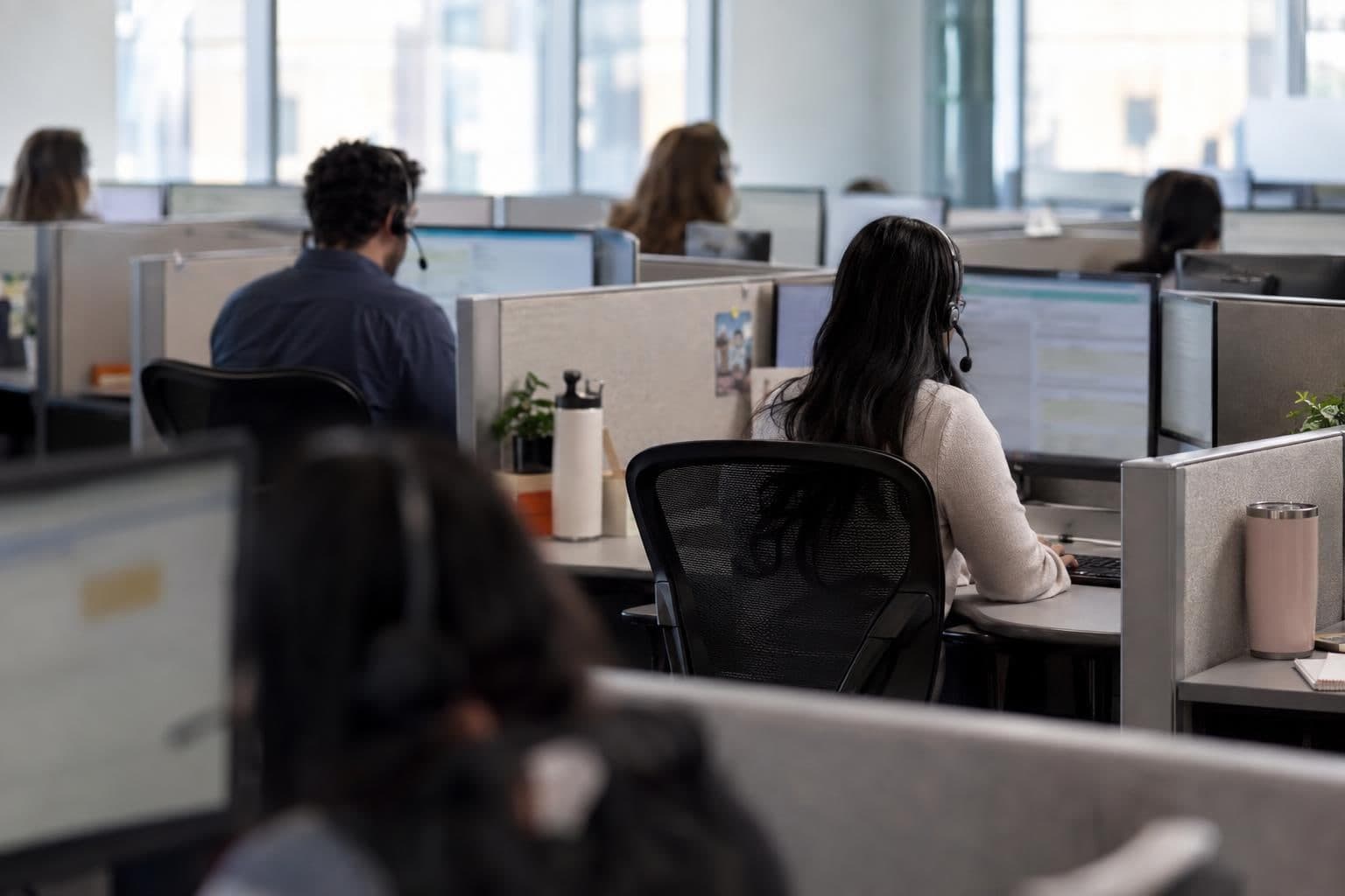 Contact-center agents handle customer calls at separate workstations.