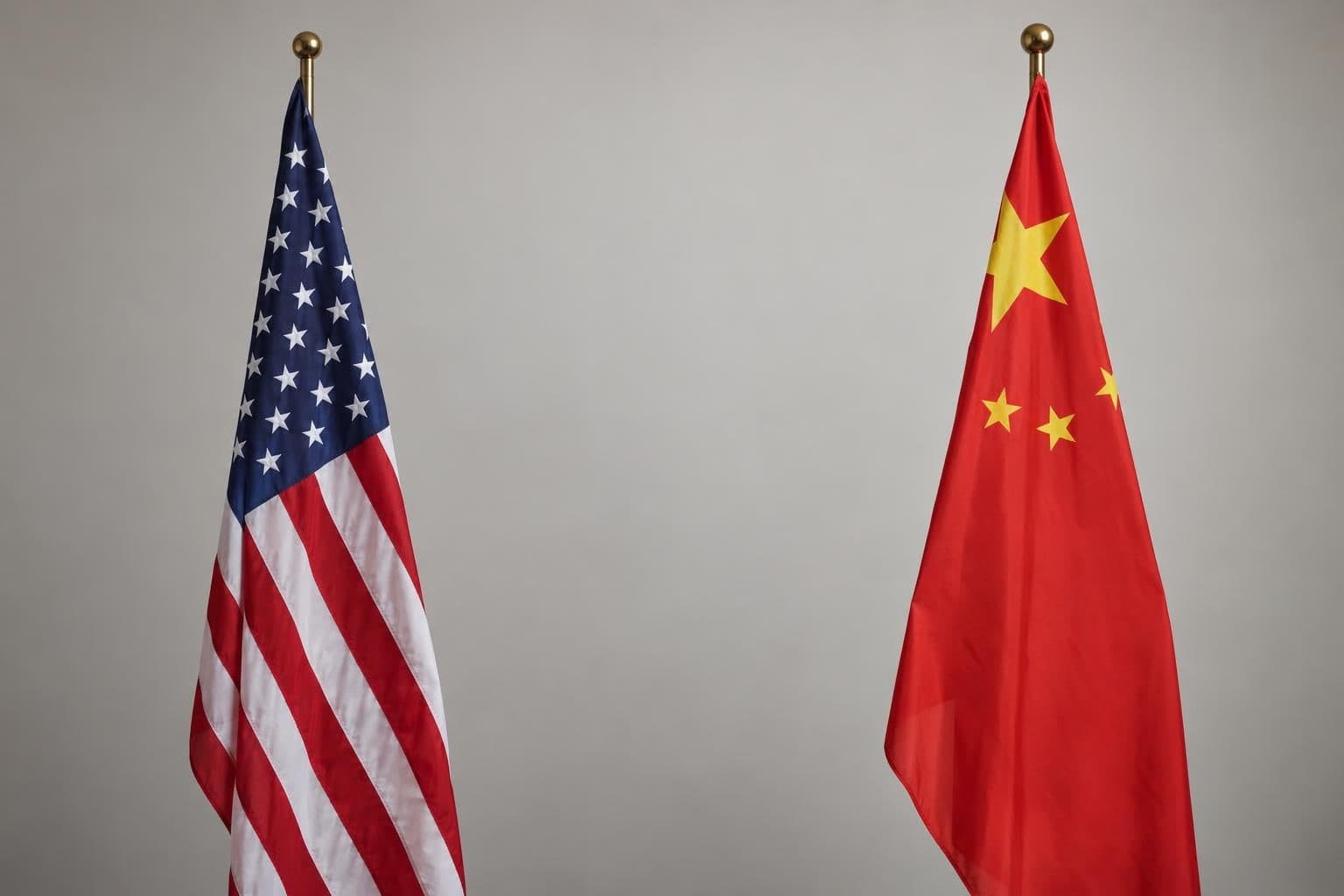 U.S. and Chinese flags stand apart against a plain background.