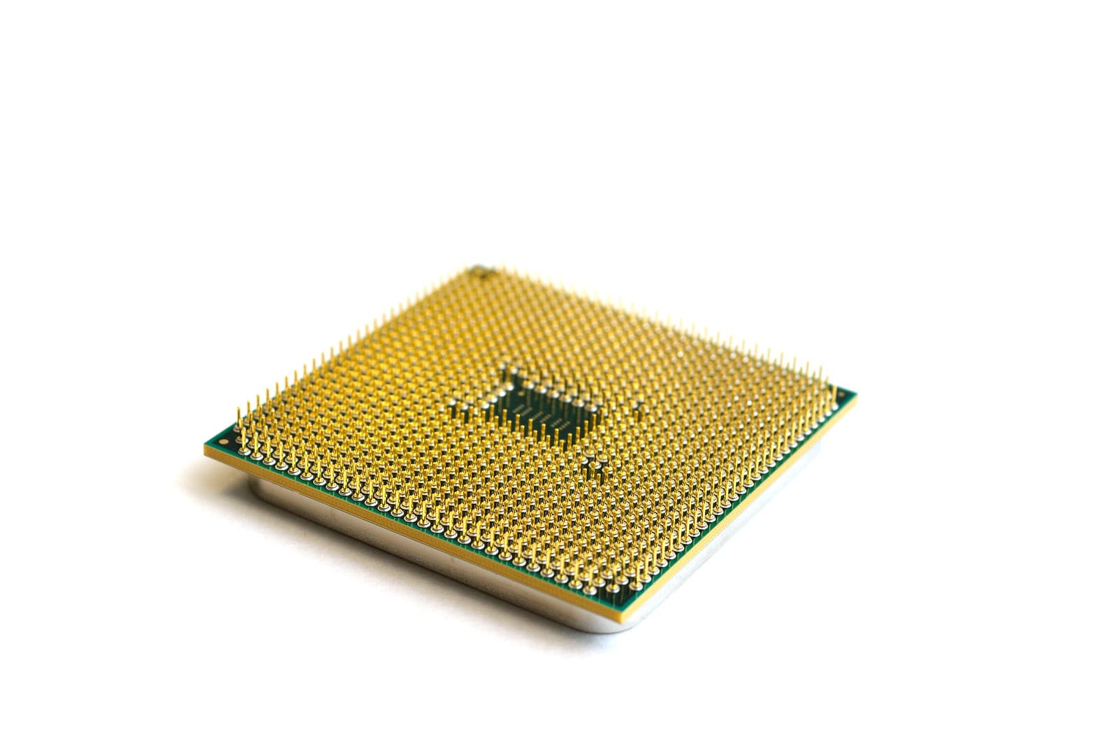 A square processor chip with a dense grid of gold pins on a white background.